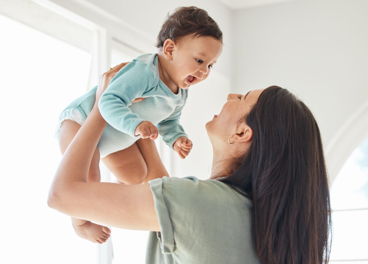Mother holding Baby in Air with both smiling at each other
